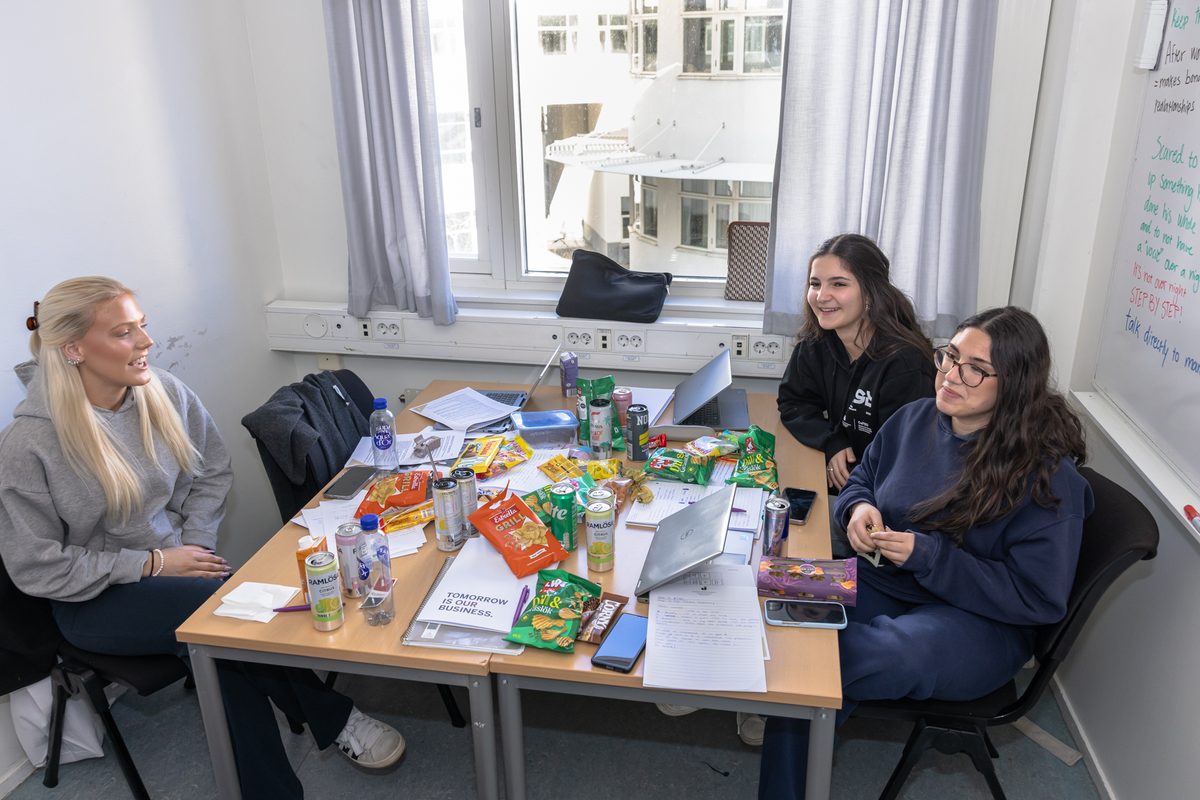 Ett lag arbetar runt ett bord med datorer och anteckningar